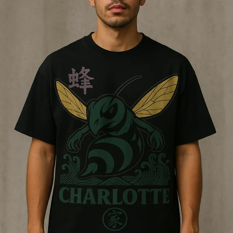 Front of Queen Sting black oversized streetwear t-shirt featuring a fierce green hornet with golden wings, Japanese wave patterns, CHARLOTTE text, and purple kanji – worn by male model.